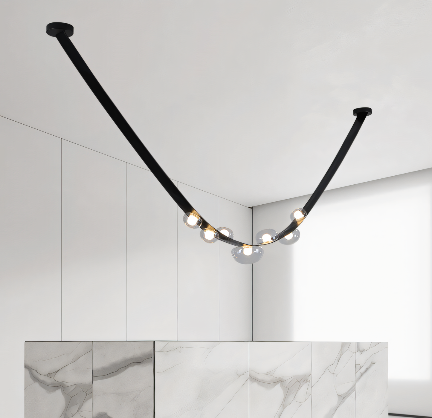 A modern chandelier with a black metal frame, black leather belt, and smoky glass globes hangs from a dining room ceiling. The chandelier casts a warm, inviting glow on the space.