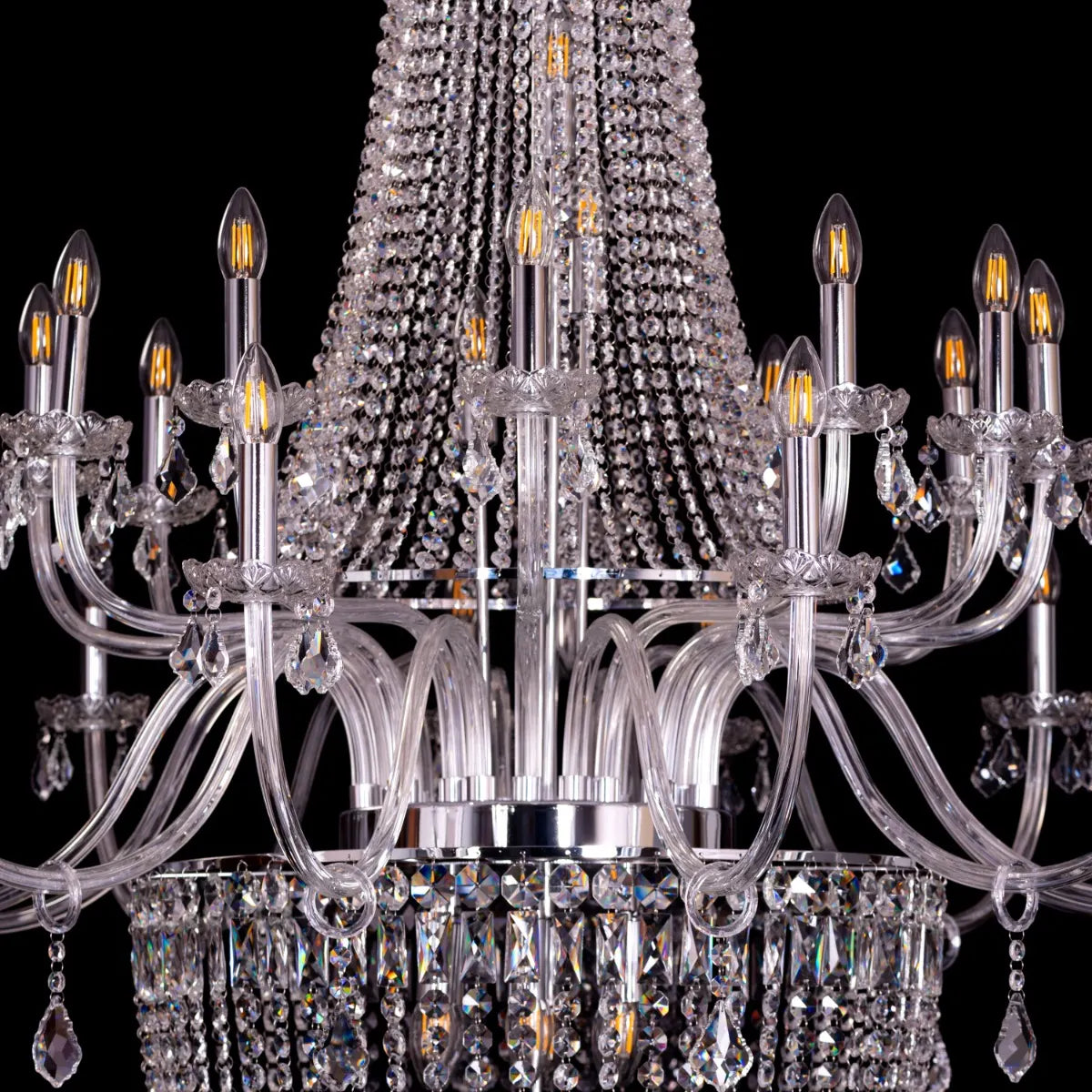 Large chrome crystal chandelier with letter-shaped elements, hanging in a luxurious living room