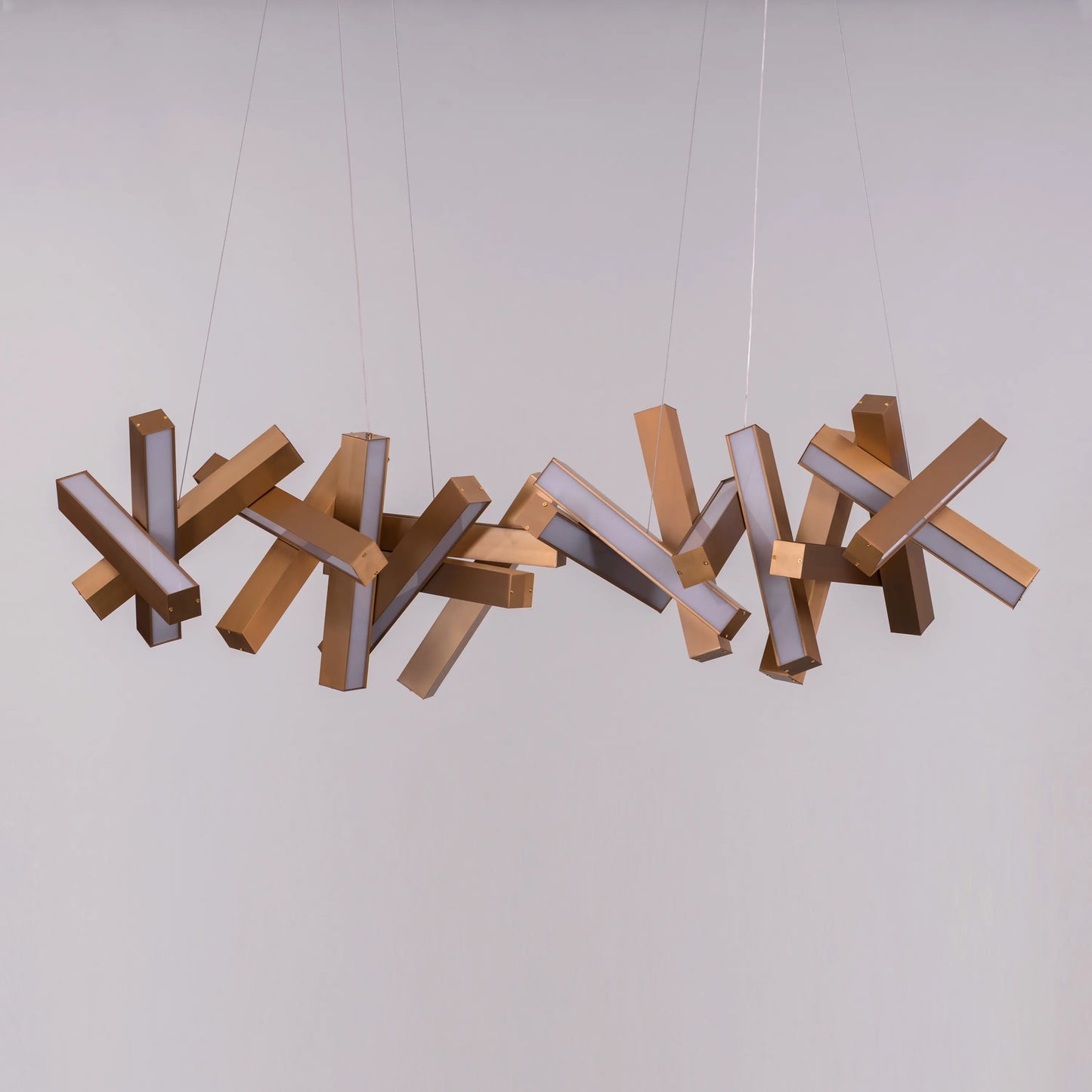 Large "Glow Miles" gold chandelier with multiple LED light sources, dramatically illuminated in a spacious, modern room.