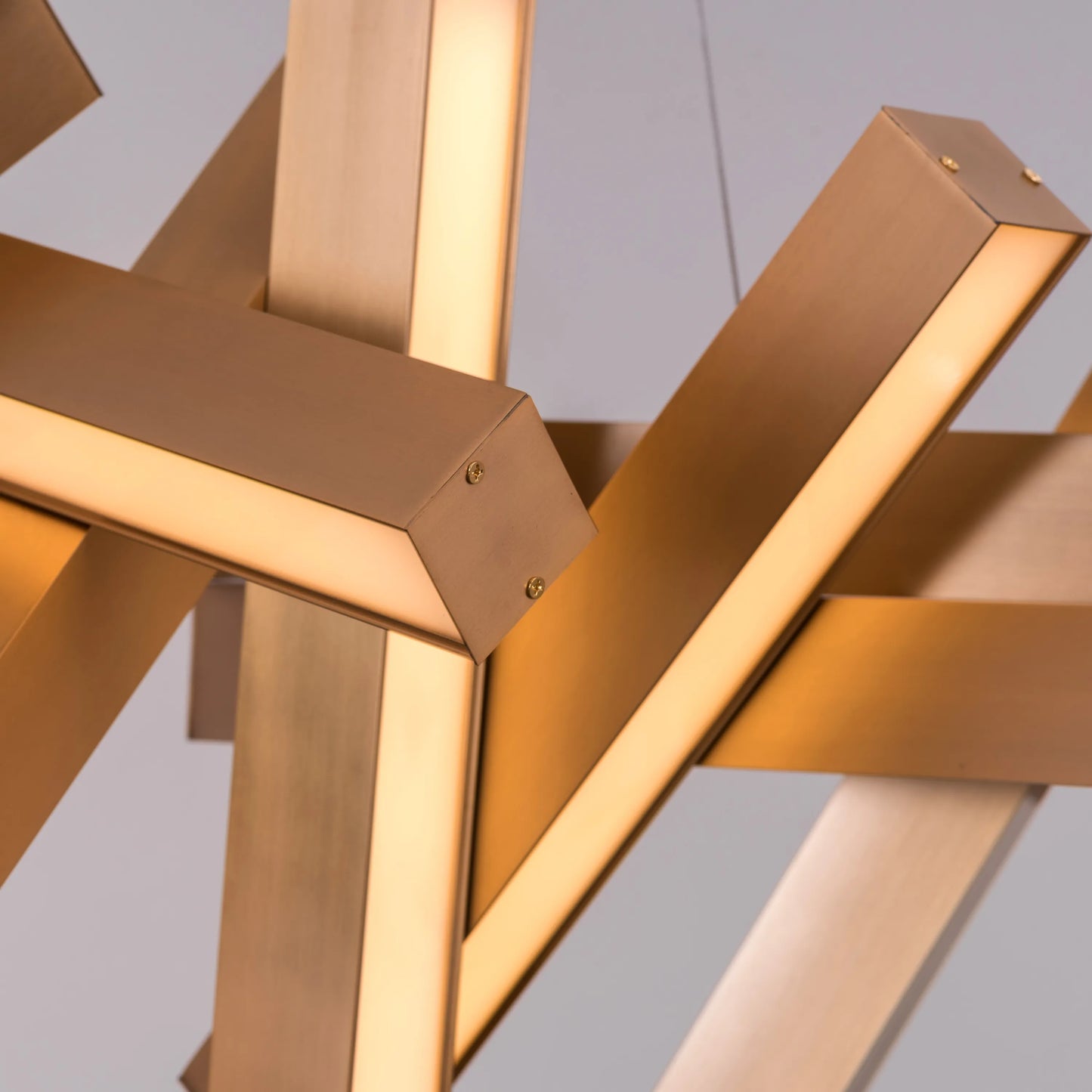 Large "Glow Miles" gold chandelier with multiple LED light sources, dramatically illuminated in a spacious, modern room.