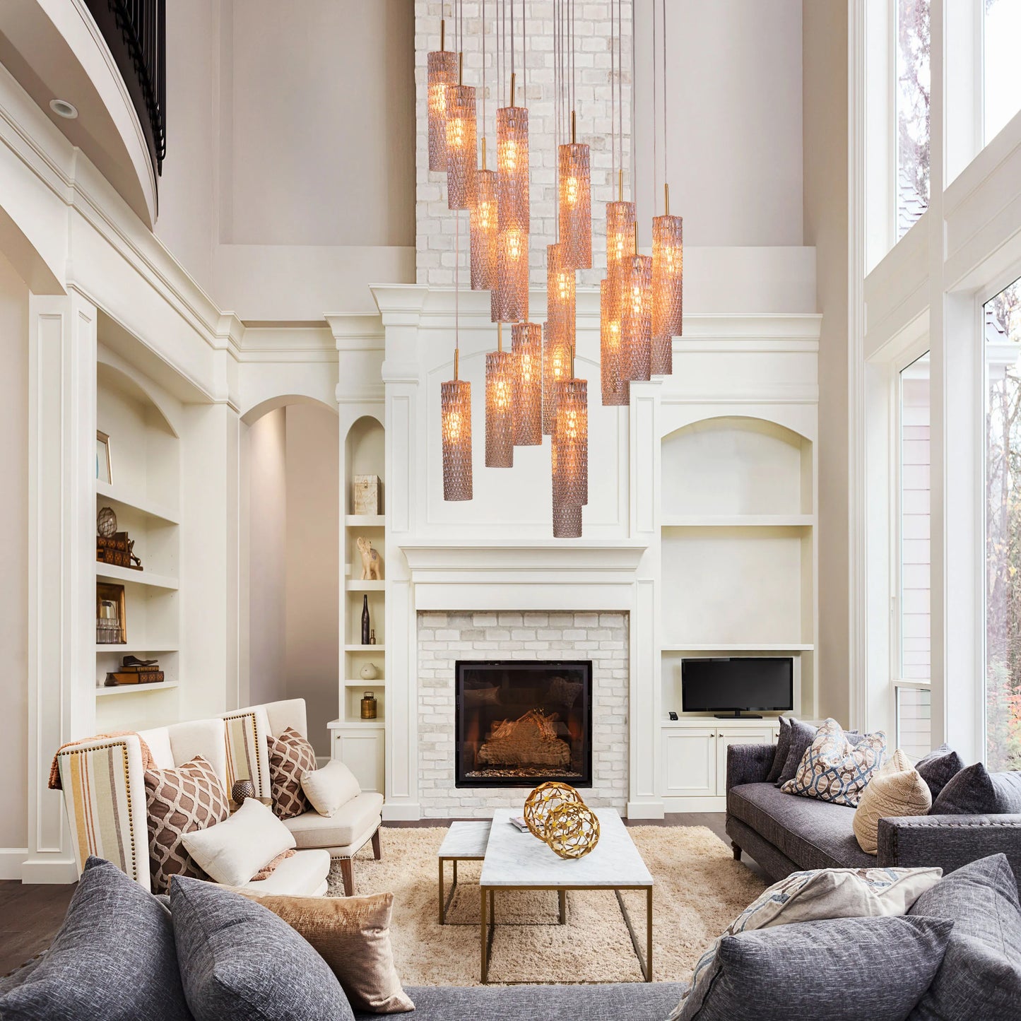 Large gold chandelier with cascading champagne glasses, resembling falling snow