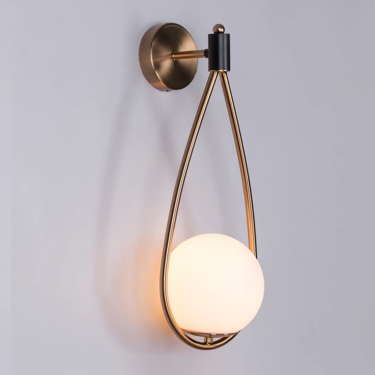 Sleek glass and metal wall light adding warmth to a minimalist living room.