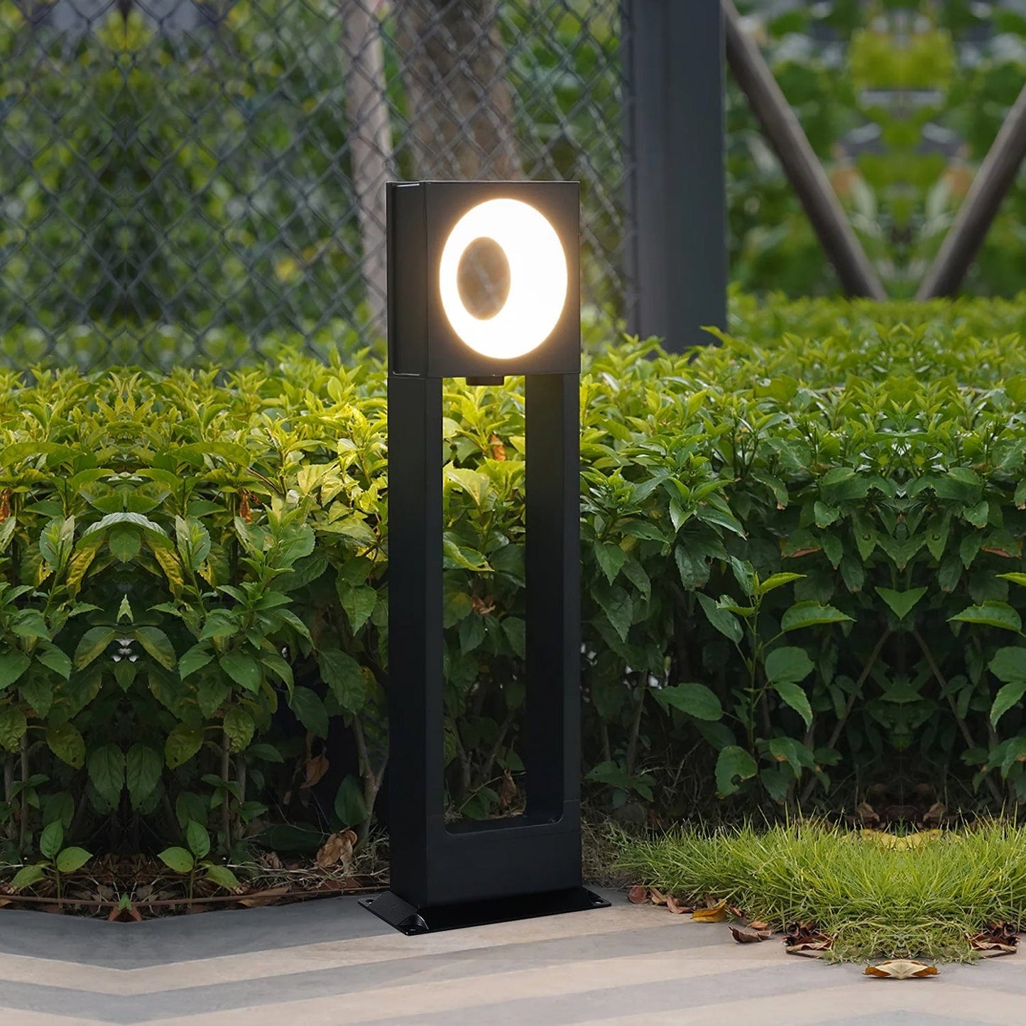 Luminara Guard Bollard Light casting warm glow on historic cobblestone street
