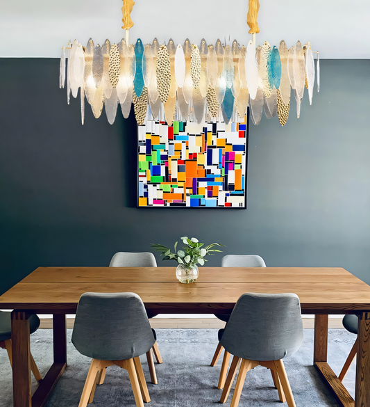 A modern oval chandelier with a white finish and gold accents hangs from a beach house living room ceiling.