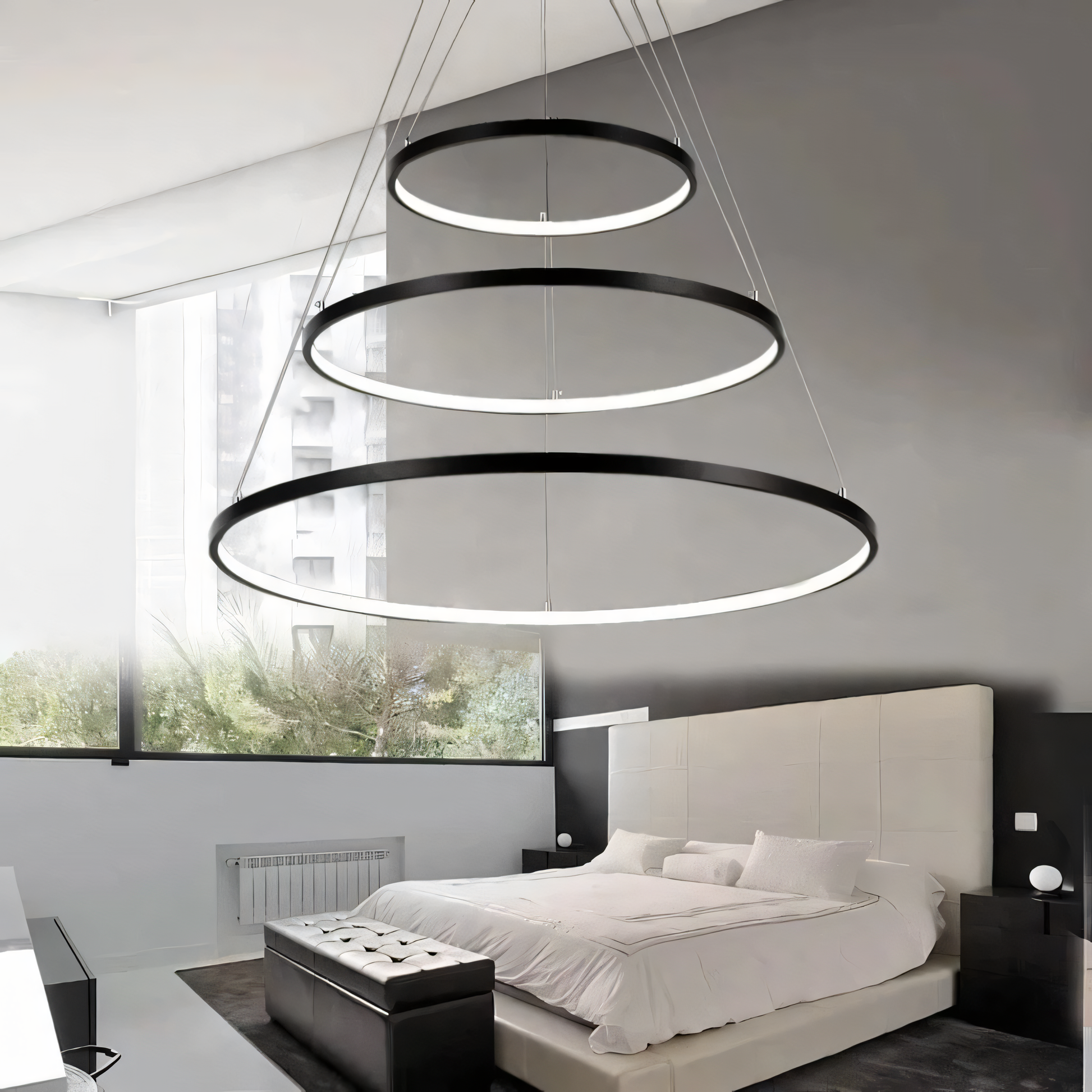 A black, futuristic chandelier with a tiered ring design hangs from a living room ceiling.