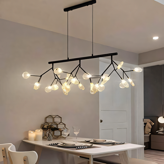 A black, circular chandelier with rods tipped with LED bulbs hangs from a dining room ceiling. The chandelier casts a warm, inviting glow on the space.