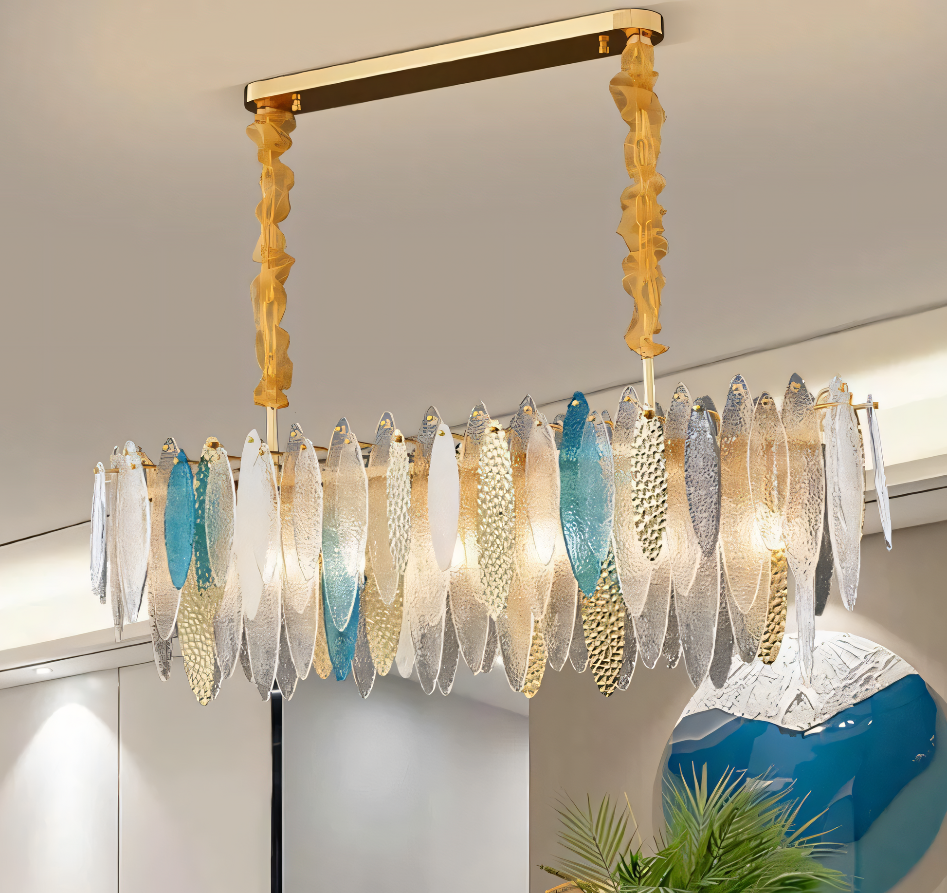 A modern oval chandelier with a white finish and gold accents hangs from a beach house living room ceiling.