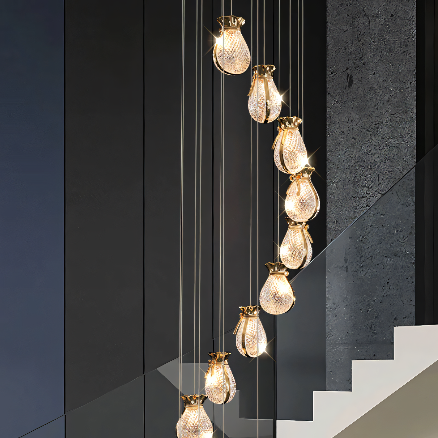 Elegant brass and crystal 6-light LED chandelier cascading down a tall staircase in a modern, luxury home interior