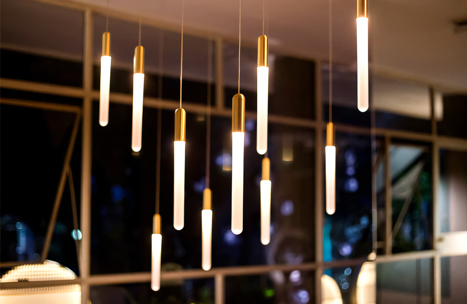 Warm LED light illuminates slender acrylic rods in this modern gold chandelier, perfect for a grand entrance or sophisticated exit.