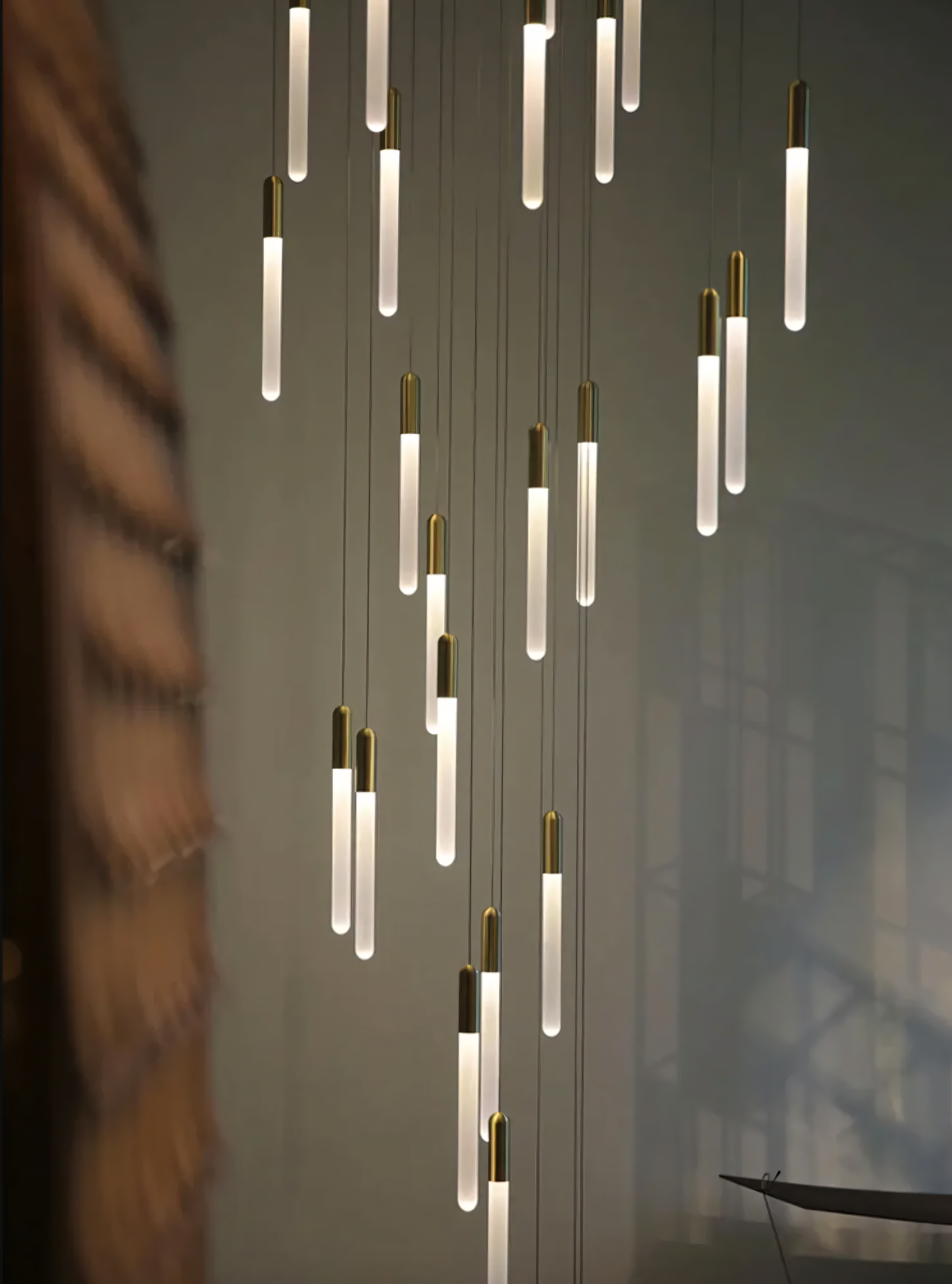 Transform your staircase into a showstopper with this cascading LED chandelier featuring acrylic rods and gold accents.