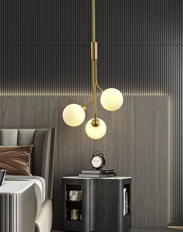 Energy-efficient LED bulbs cast a soft light through the frosted glass balls of this modern gold chandelier.