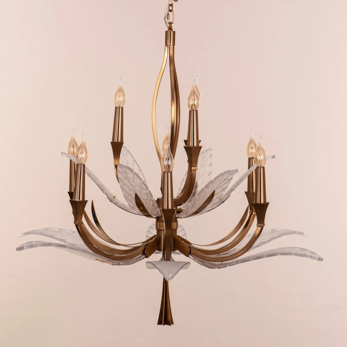 Medium-sized gold chandelier with unique glass elements, suspended in a contemporary living room