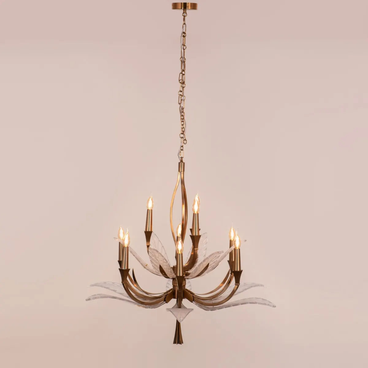 Medium-sized gold chandelier with unique glass elements, suspended in a contemporary living room