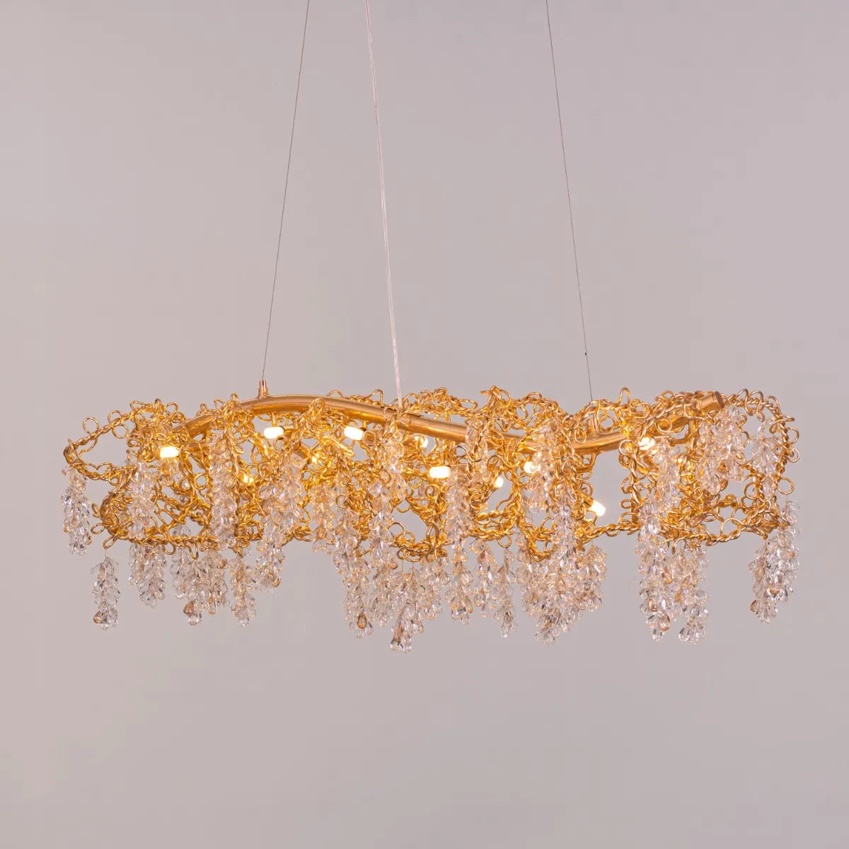 Believe In Magic large gold crystal chandelier illuminating an elegant living room