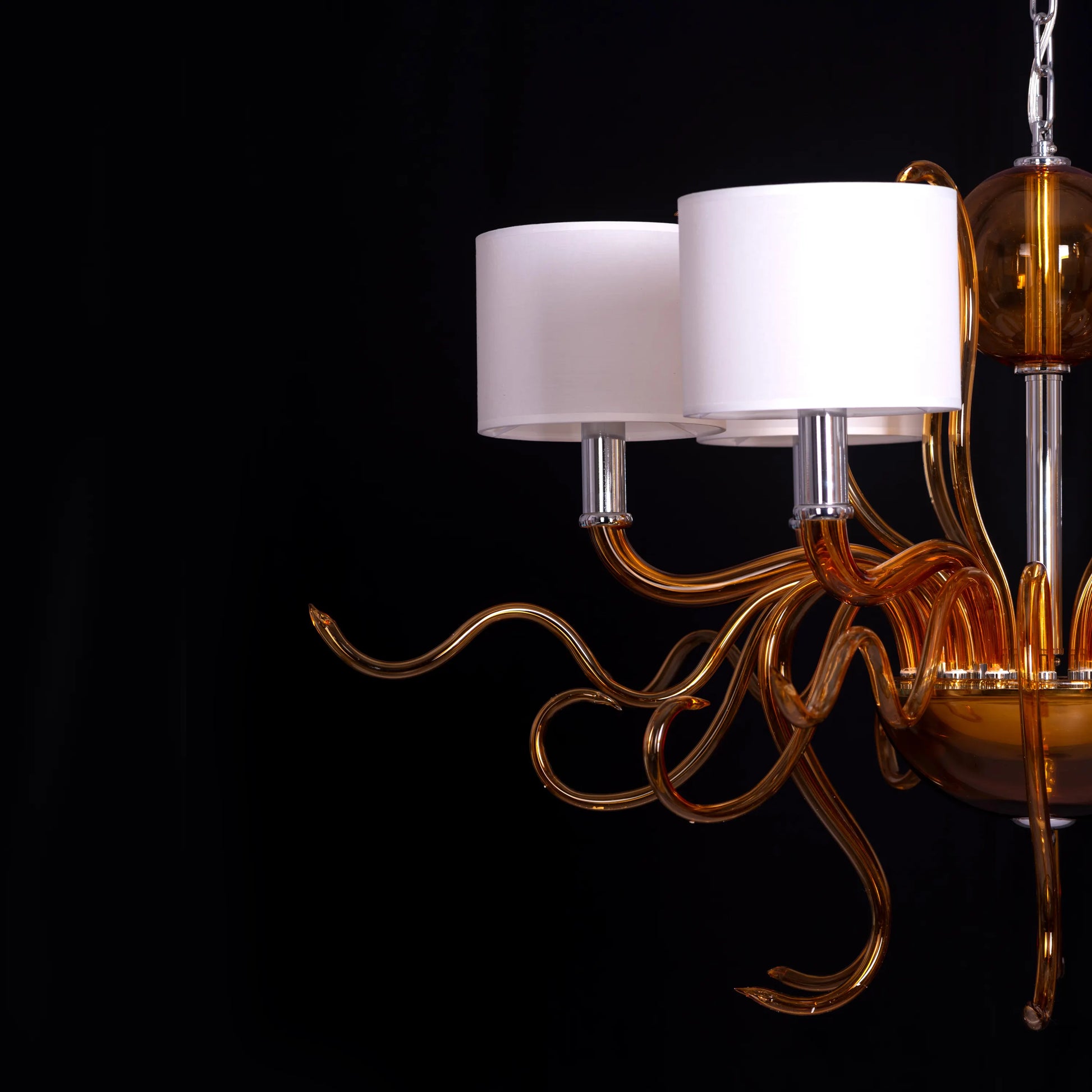 Large clear glass chandelier with chrome, amber, and white elements suspended in harmonious arrangement