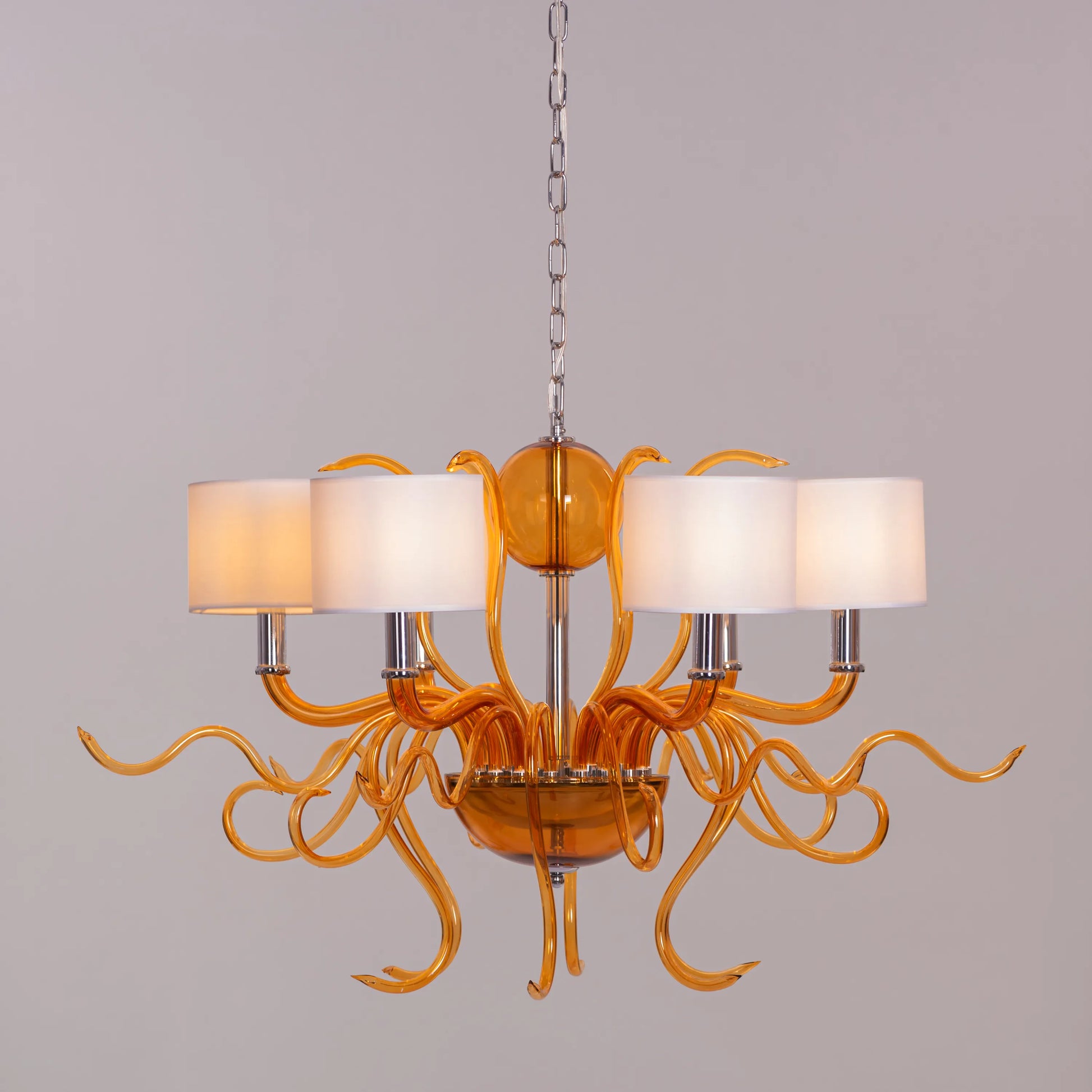 Large clear glass chandelier with chrome, amber, and white elements suspended in harmonious arrangement