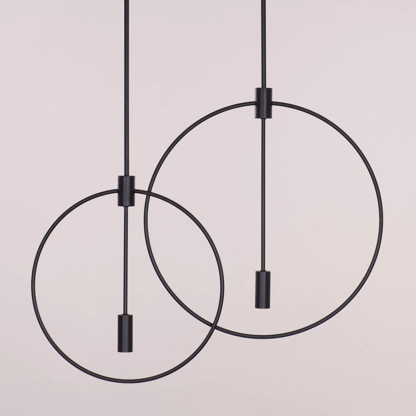 Ring On It Black Chandelier suspended in a modern living room, emitting a warm white glow