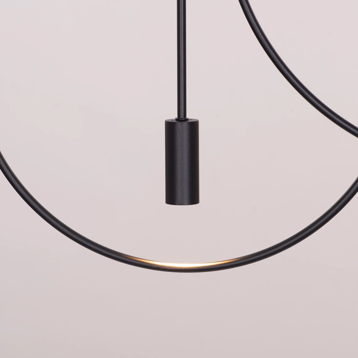 Ring On It Black Chandelier suspended in a modern living room, emitting a warm white glow