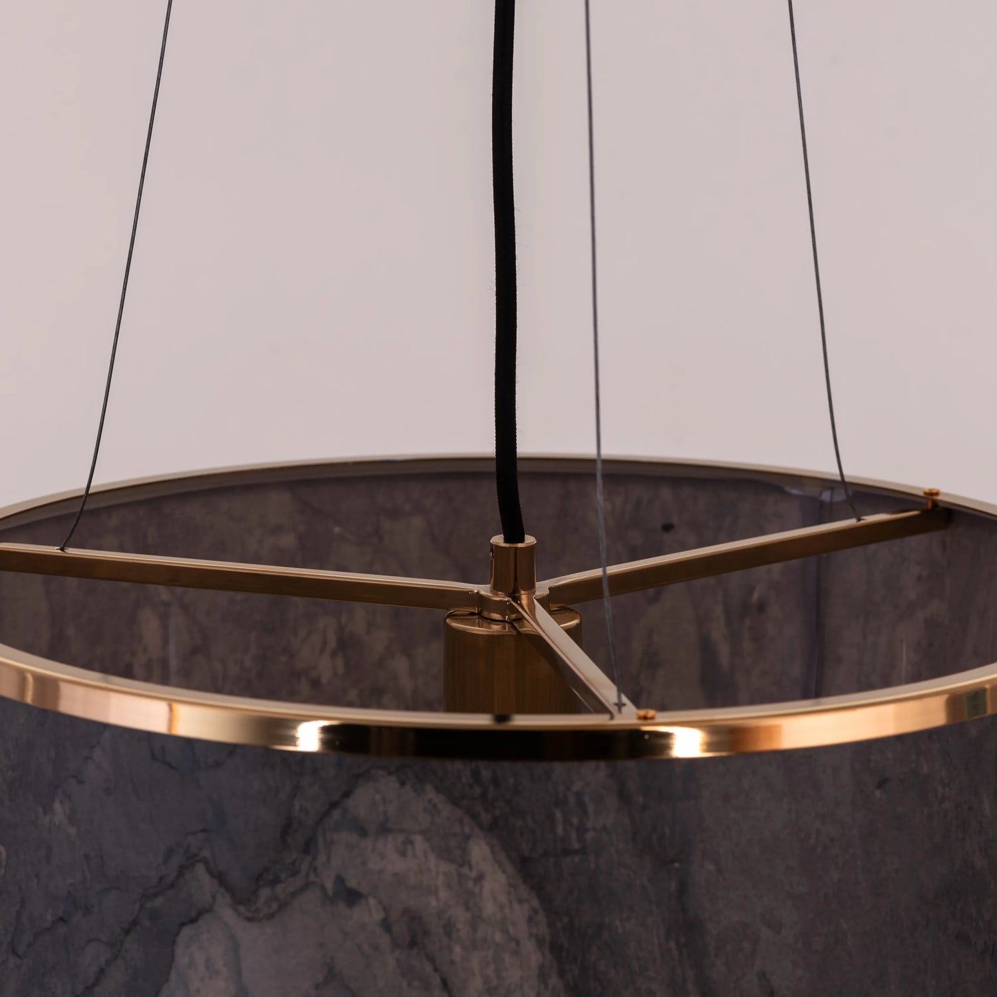 A contemporary pendant light named 'Touch & Glow,' featuring a striking gold stone veneer shade. The light's sleek design showcases the natural texture of the stone, beautifully reflecting and diffusing light to create a warm, inviting ambiance. This pendant light adds a touch of luxury and sophistication, making it an ideal choice for modern interiors.