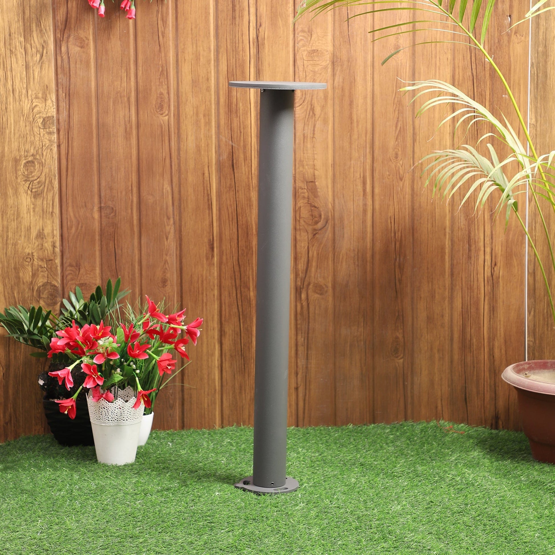 Minimalist circular bollard light blending with nature